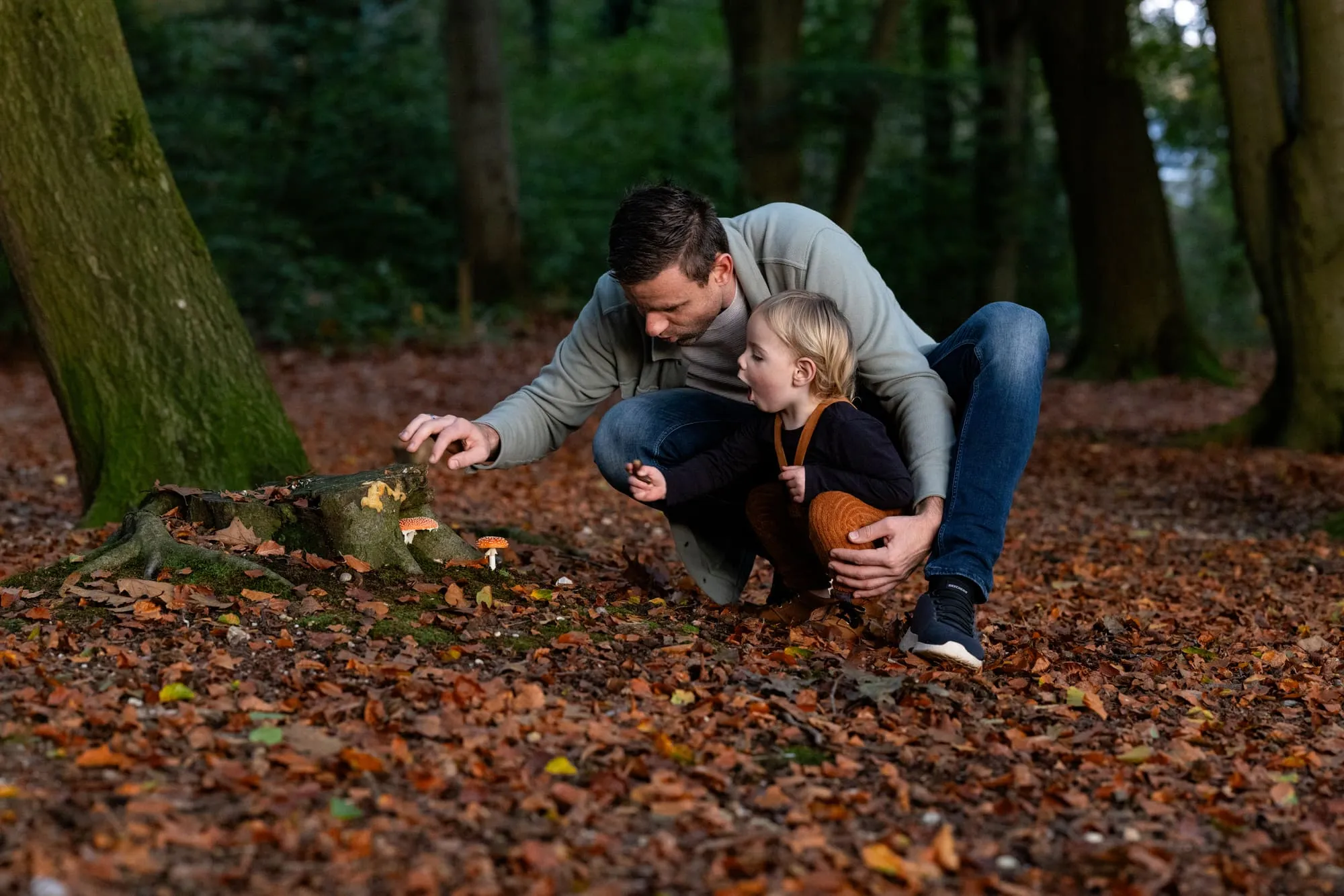 Vader en dochter ontdekken samen paddenstoelen in het bos