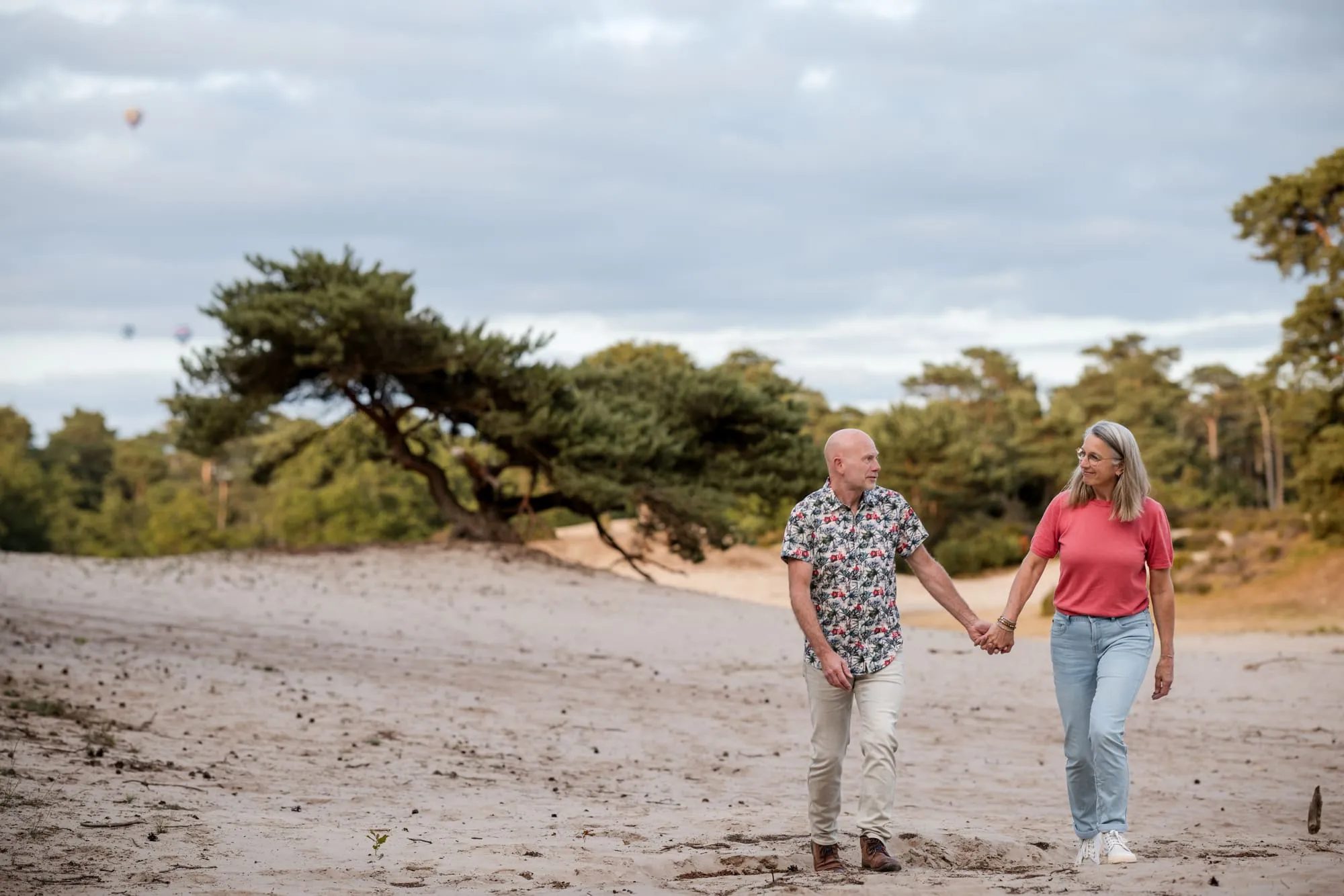 Het stel wandelt hand in hand over het zand van de zandverstuiving