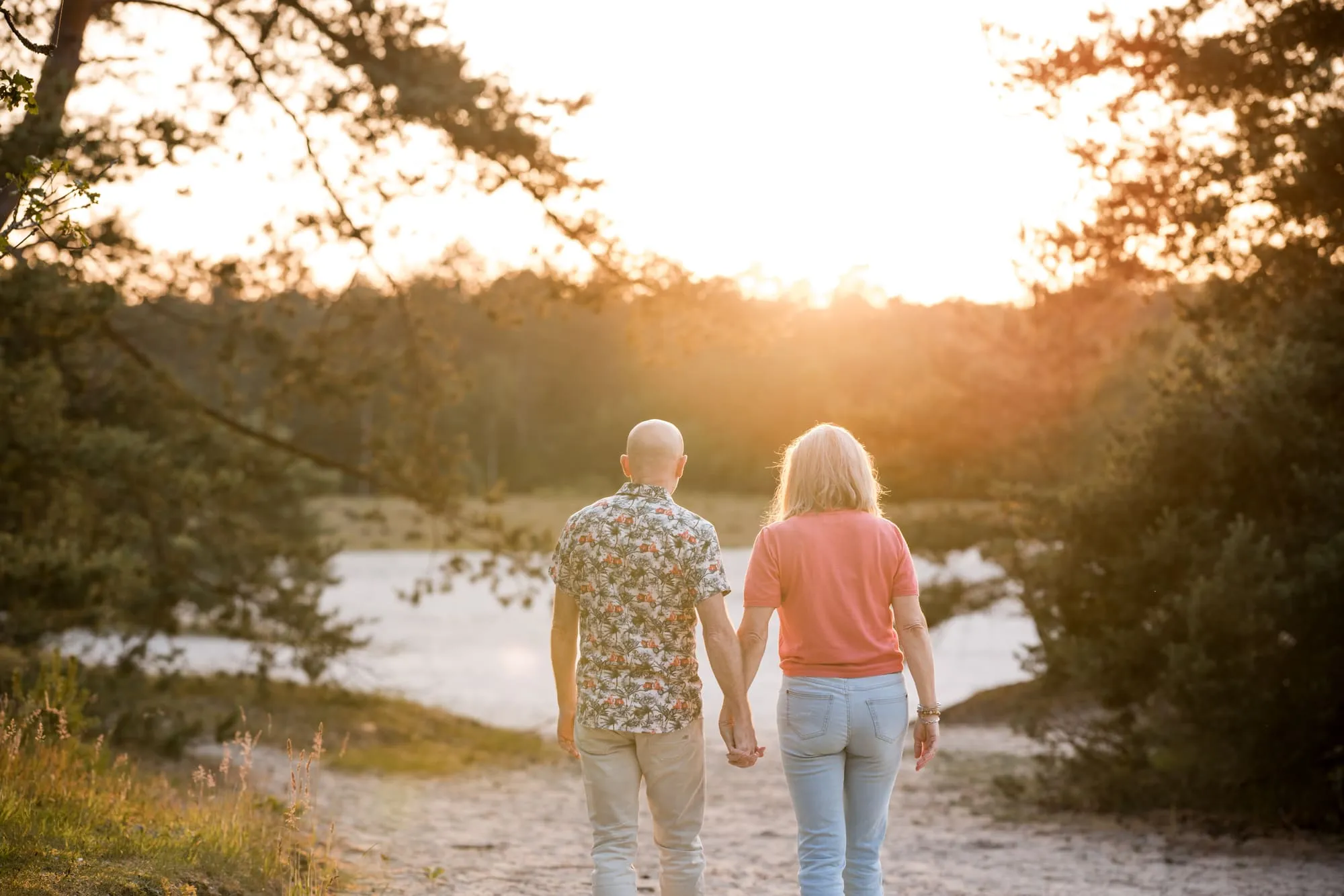 Het stel loopt hand in hand de ondergaande zon tegemoet