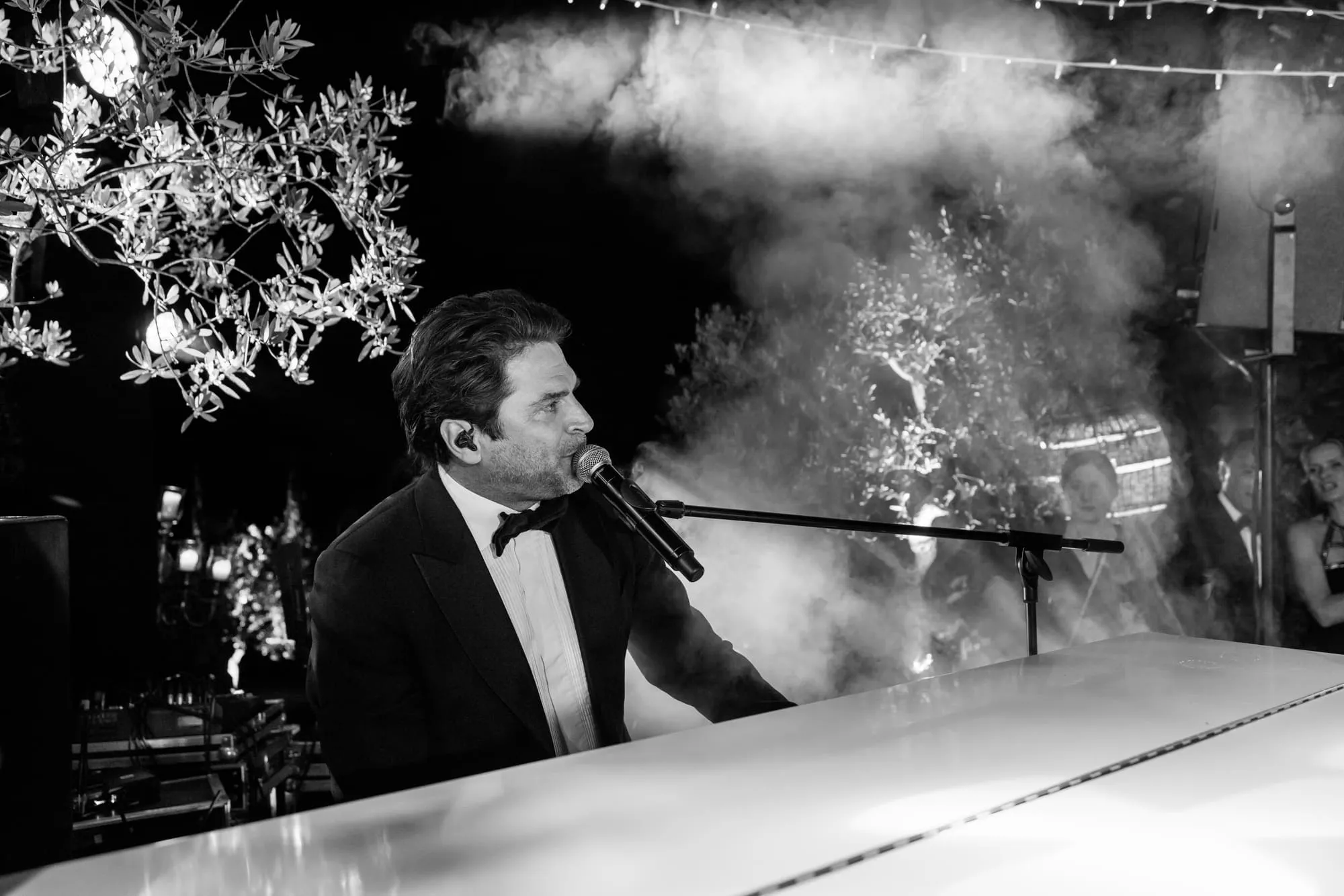 Zwart-witbeeld van een zanger achter de microfoon tijdens het avondfeest