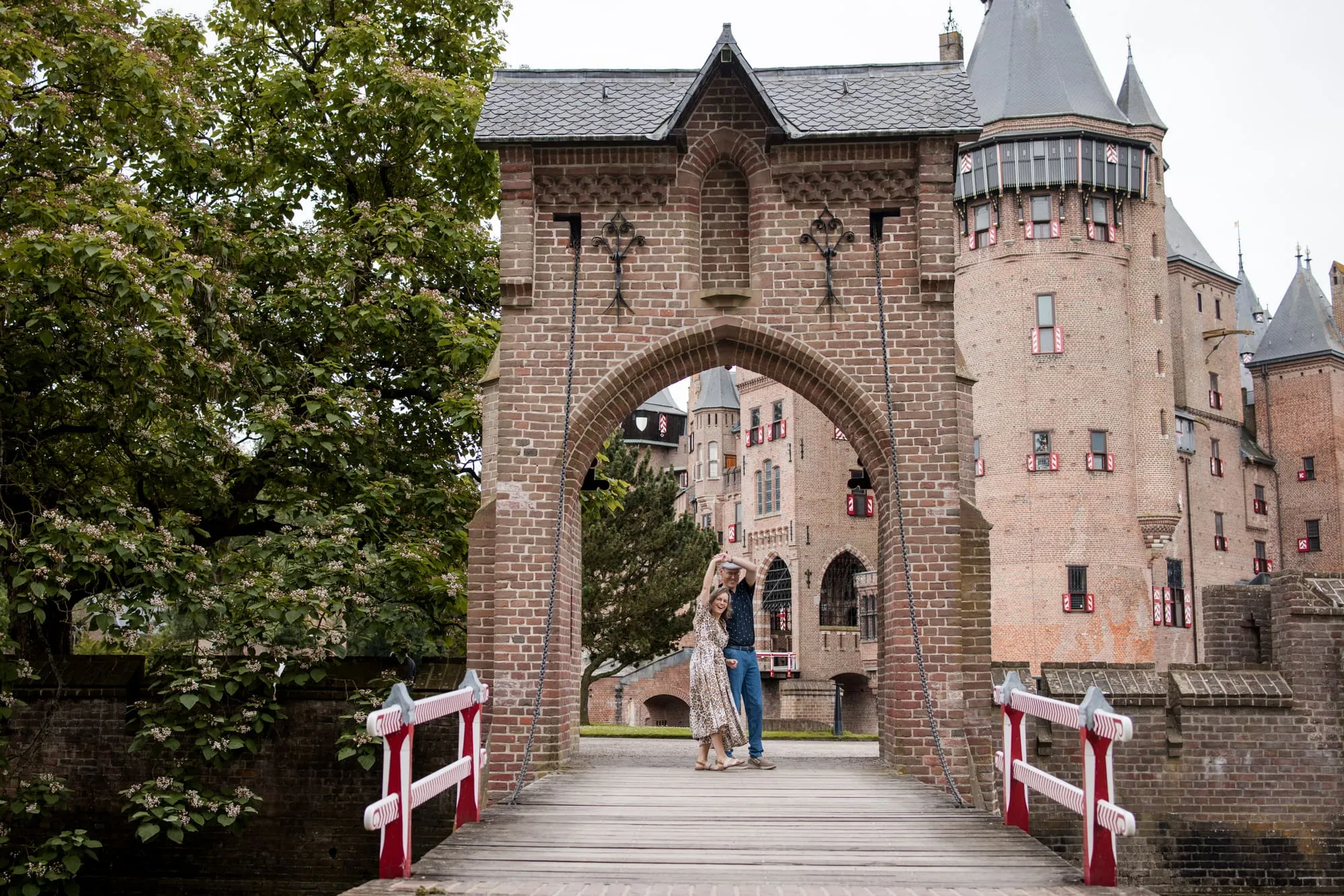 Het stel staat klein in de poort van het kasteel, gezien vanaf de brug