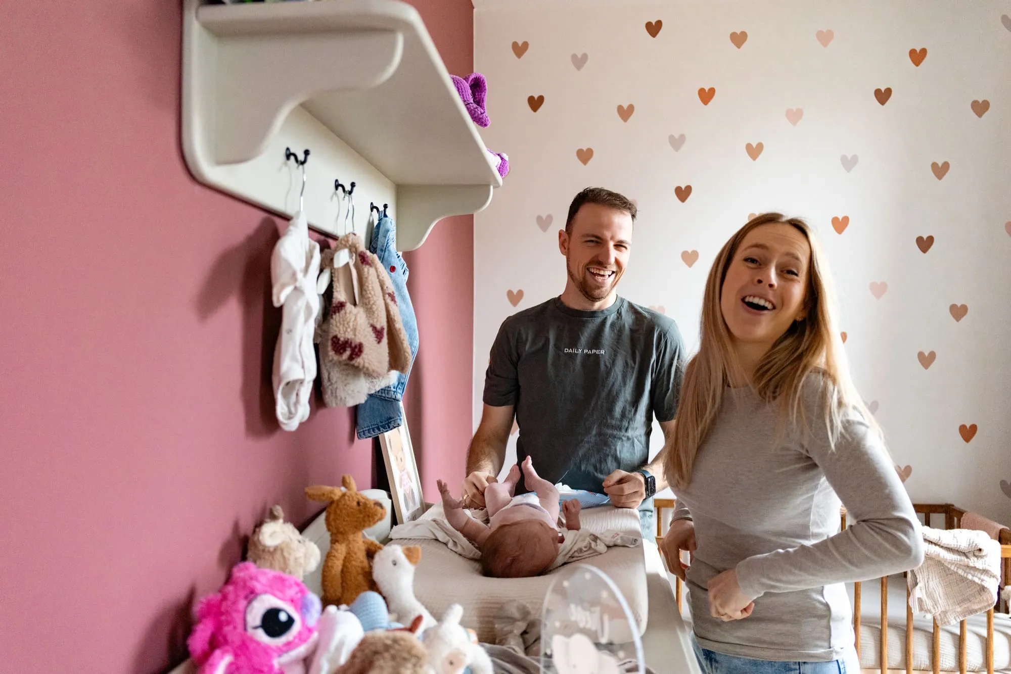 Vader en moeder lachen samen in de babykamer