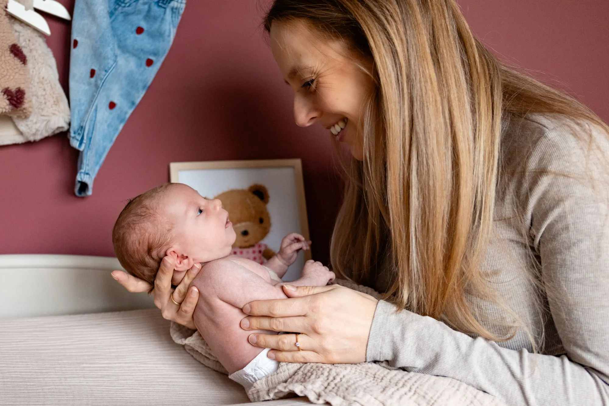Moeder houdt haar pasgeboren baby vast en lacht naar haar
