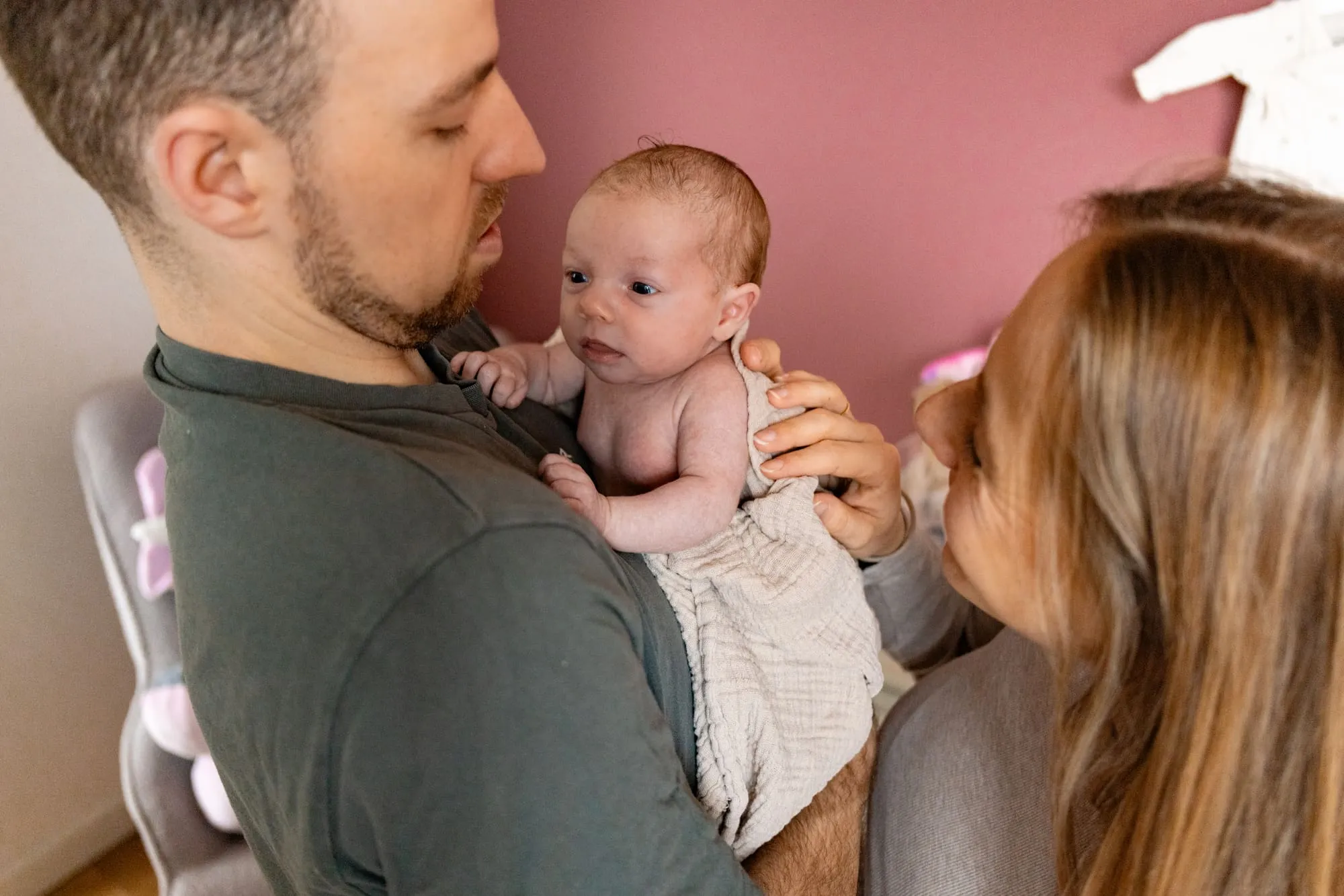 Vader tilt de baby omhoog naar moeder, die haar een kus geeft