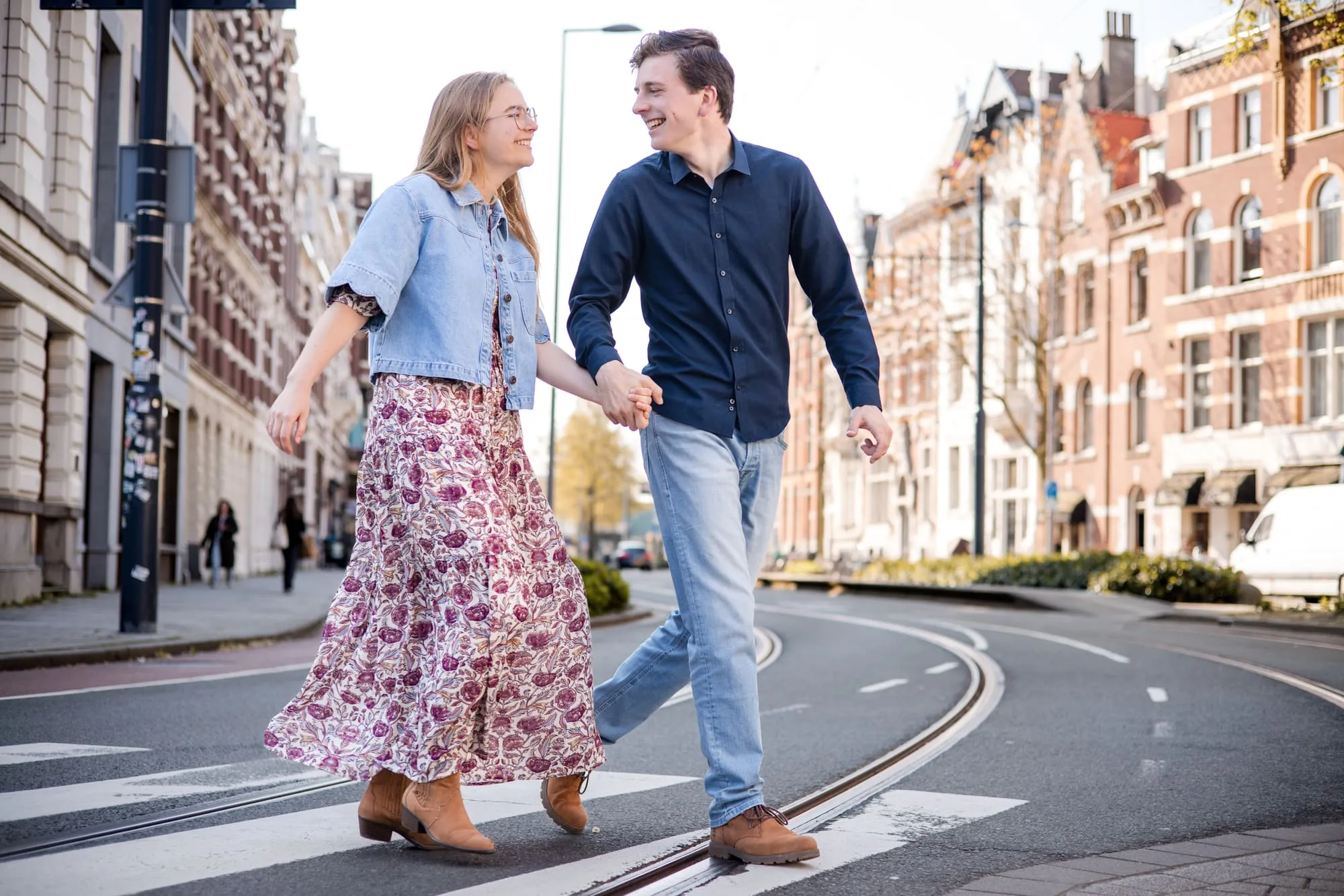 Het stel steekt hand in hand een lege straat over
